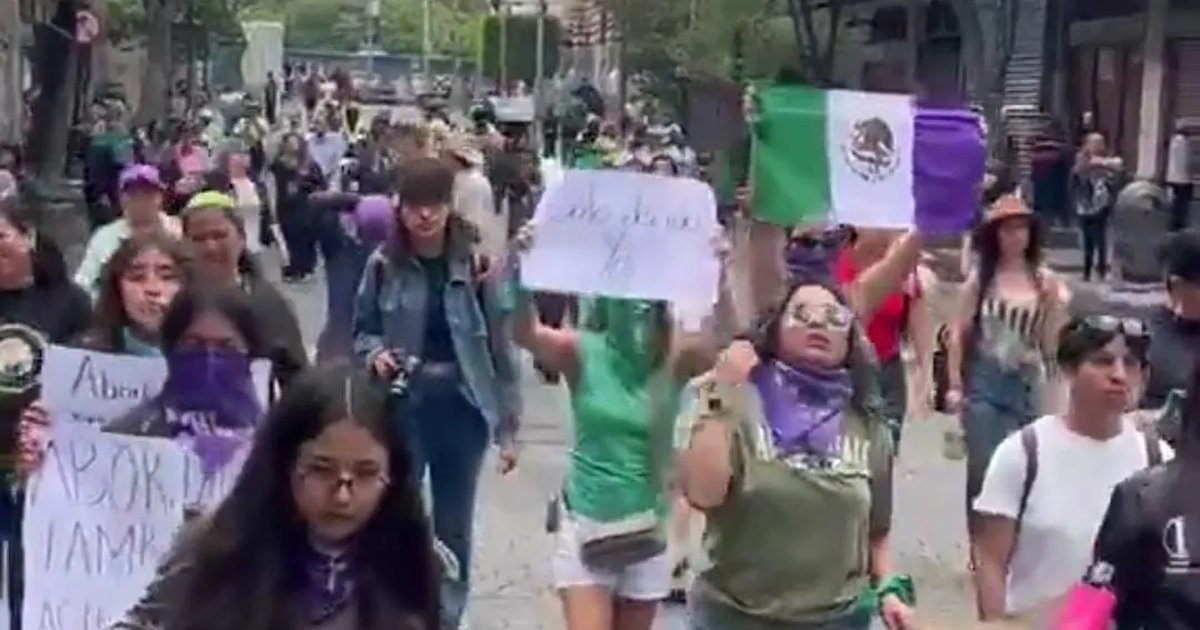 Women wearing green handkerchiefs march through central Mexico City carrying signs demanding legal, safe and free abortion