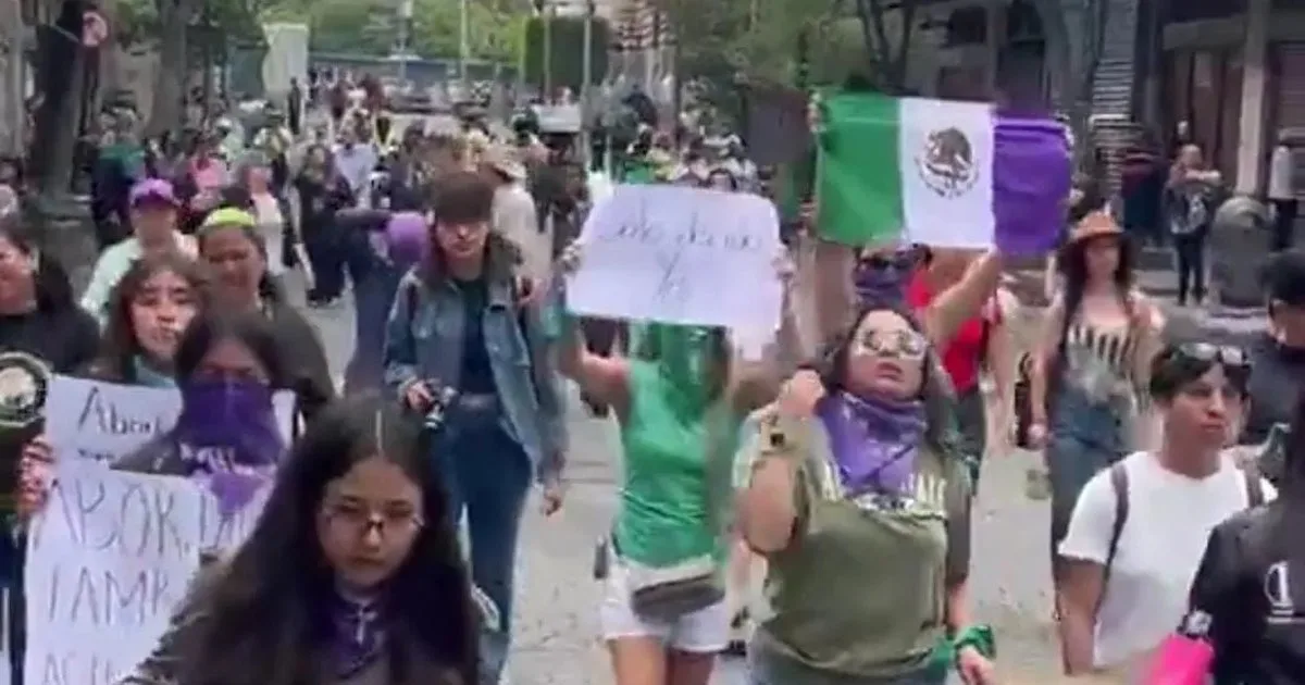 Women wearing green handkerchiefs march through central Mexico City carrying signs demanding legal, safe and free abortion