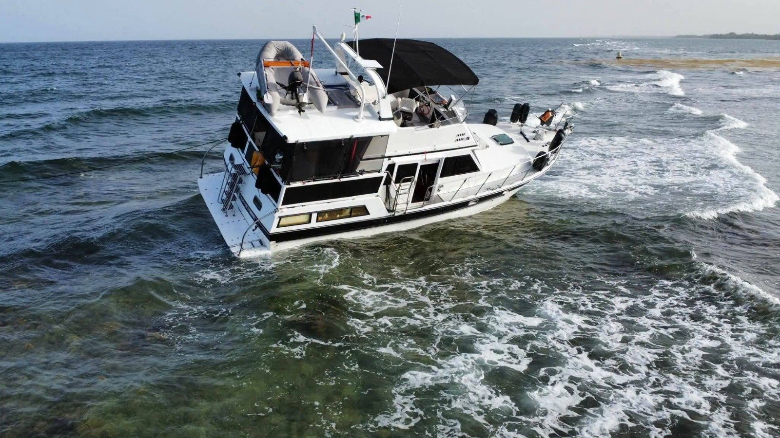 A private motor yacht stranded on a coral reef area off the coast of Mahahual, Quintana Roo