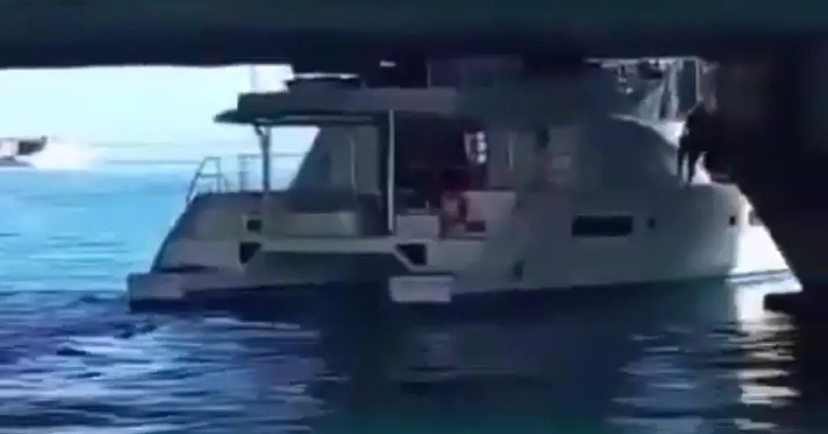 A yacht lodged against the structure of the Calinda Bridge in Cancún's Hotel Zone as maritime and municipal authorities assess the scene