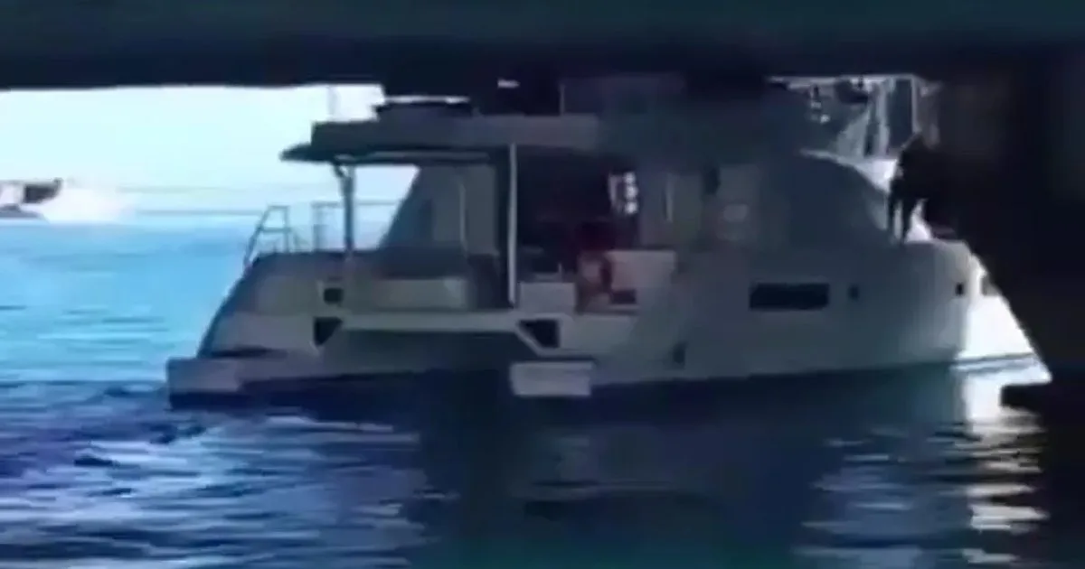 A yacht lodged against the structure of the Calinda Bridge in Cancún's Hotel Zone as maritime and municipal authorities assess the scene
