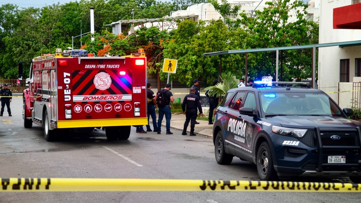 Security and forensic personnel outside a home in Playa del Carmen where a man's body was found in an advanced state of decomposition