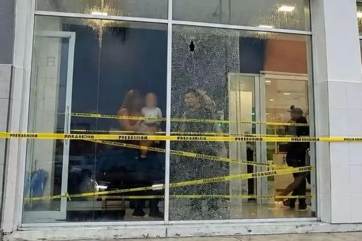 Shattered glass and bullet holes in the facade of a BBVA bank branch in Puerto Aventuras, Quintana Roo