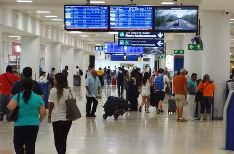 Travelers walking through the passenger terminal at Cancún International Airport in Quintana Roo, Mexico