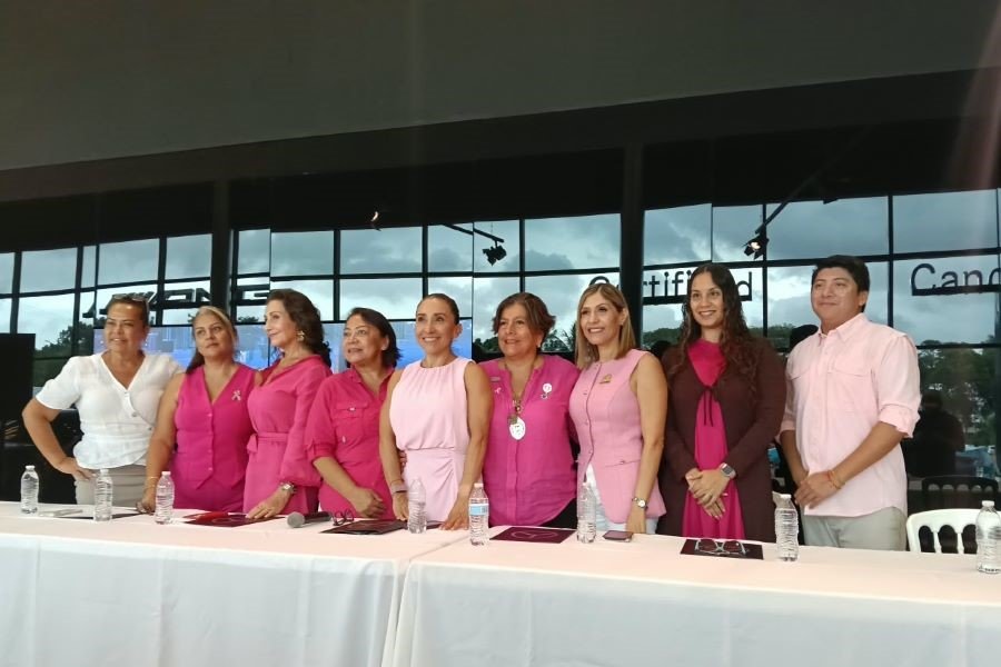 Participants wearing pink walk across the Nichupté Bridge in Cancún during a charity event supporting breast cancer survivors