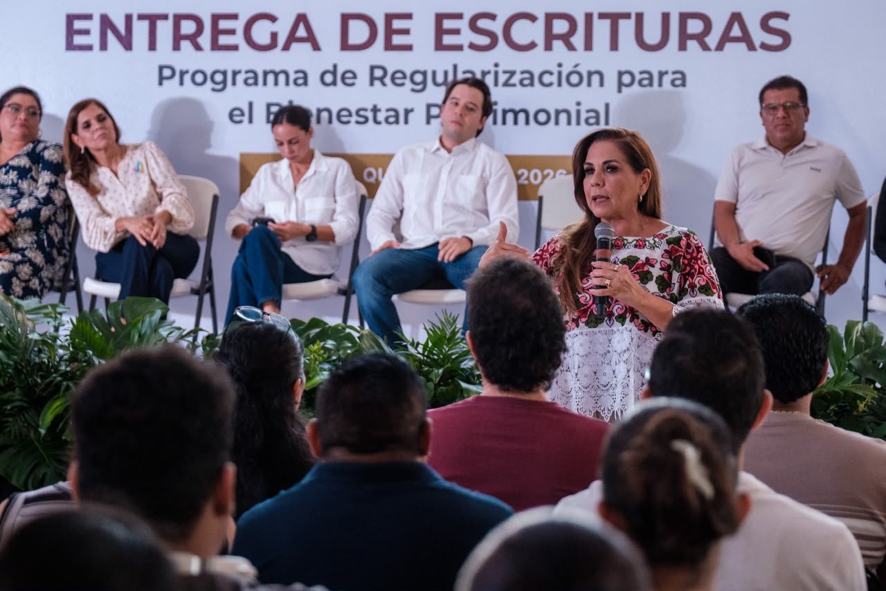 Government officials hand property deeds to residents during a land regularization ceremony at Malecón Tajamar in Cancún, Quintana Roo