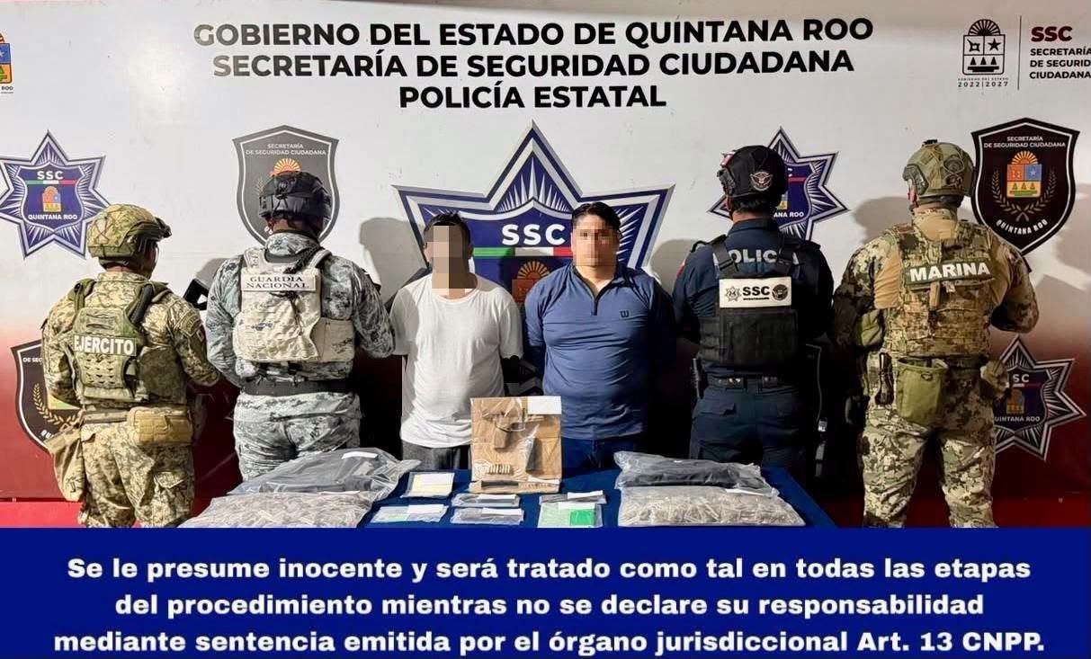 Police officers in Cancún display seized bags of marijuana, a handgun, magazines, backpacks and cell phones after arresting two Interpol-wanted fugitives.