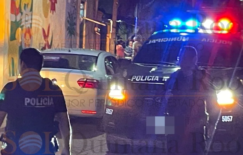 Police officers and patrol vehicles deployed on a Cancún street after an armed robbery near Supermanzana 8