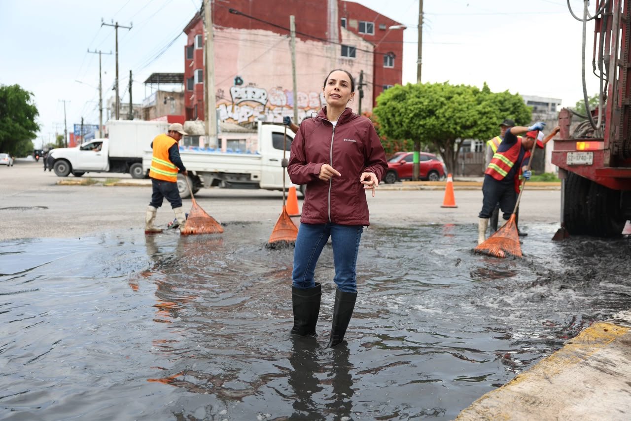Municipal workers in Cancún clear drains and pump water from flooded streets during a rain response operation