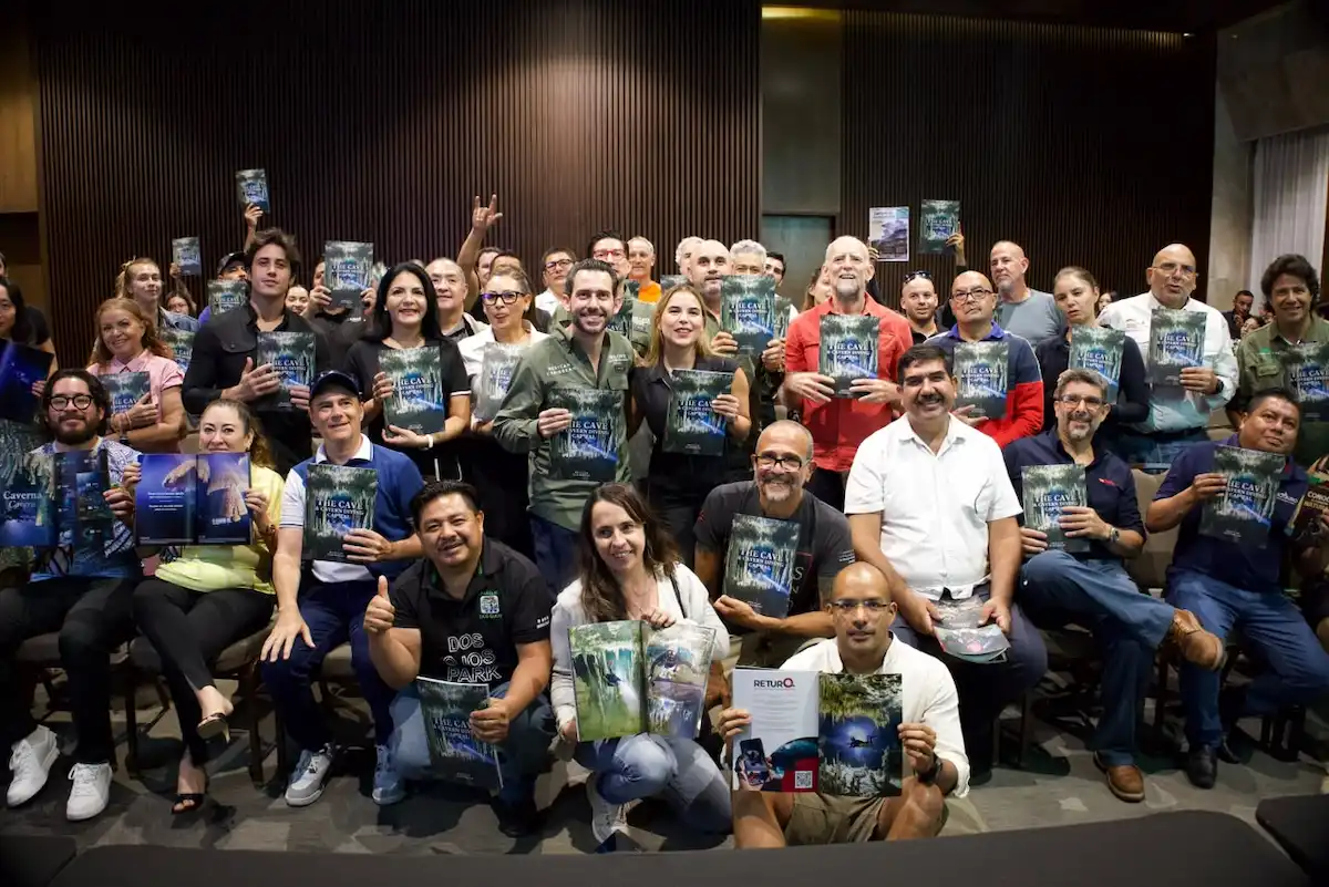 Participants pose together at the launch event, enthusiastically displaying their new copies of the publication focused on cave ecosystems.