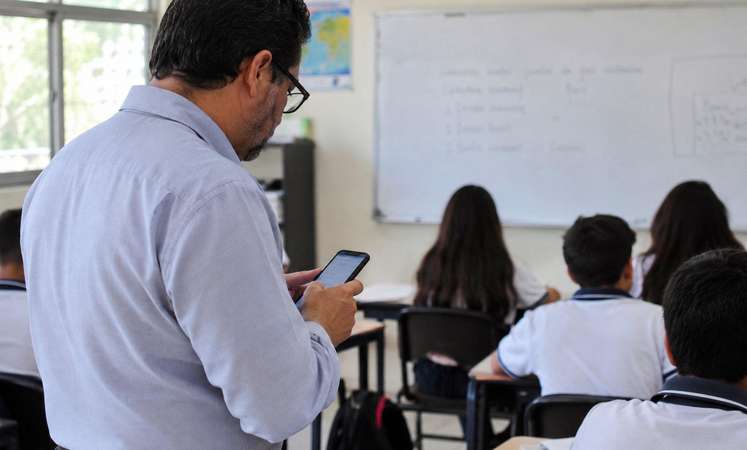 A stack of confiscated cellphones inside a clear storage box at a school in Quintana Roo