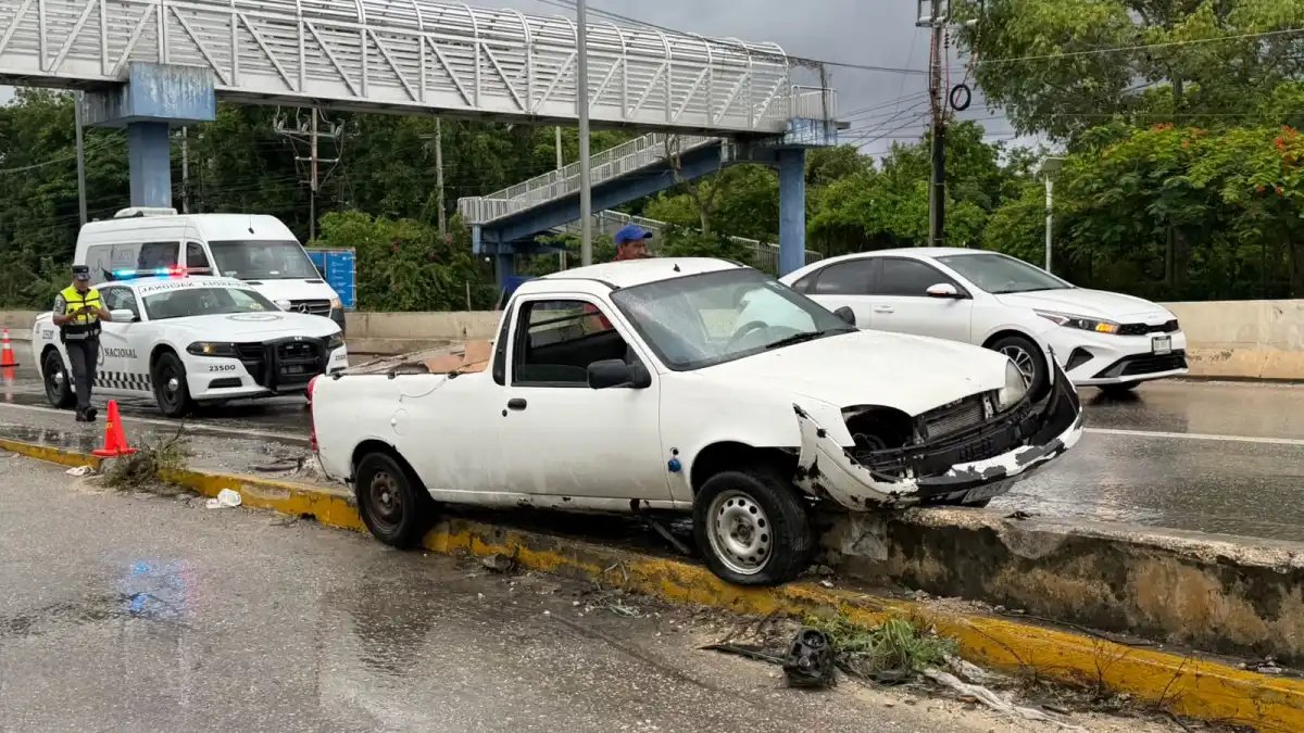 A damaged Chevrolet Tornado pickup truck resting against the concrete base of a bridge guardrail on Federal Highway 307 in Puerto Aventuras