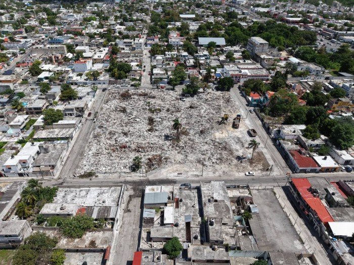 Workers and heavy equipment clear rubble at the demolished site of the old Hospital General de Cancún, where a new maternal-infant hospital will be built