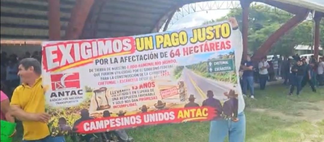 Residents of the Ramonal and Sacxan ejidos stand along Federal Highway 186 near Francisco Villa in Othón P. Blanco, Quintana Roo, holding banners during a protest over unpaid land compensation