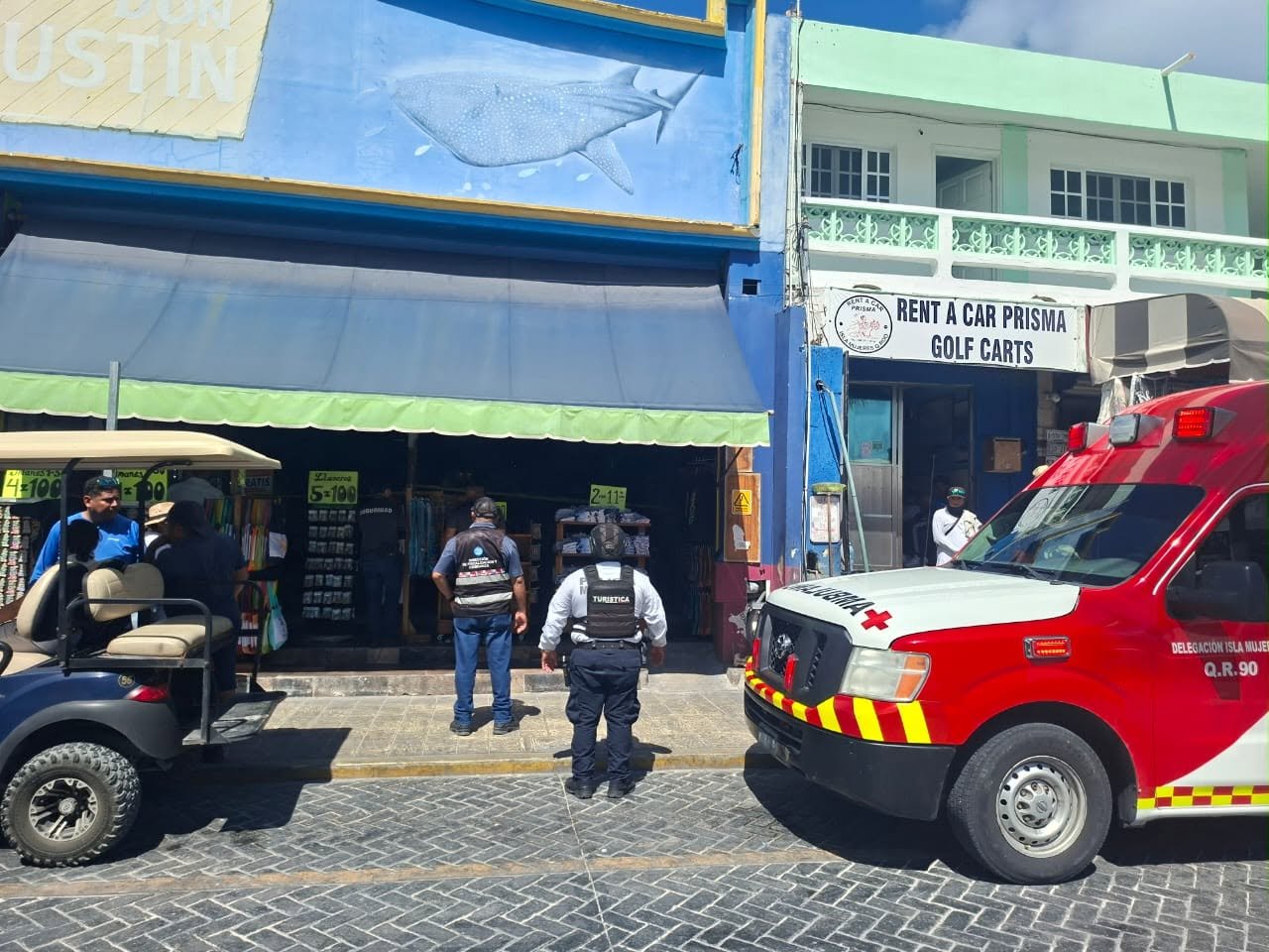 Municipal police and emergency vehicles outside a commercial establishment on Avenida Rueda Medina in Isla Mujeres, where a foreign tourist died after a medical emergency