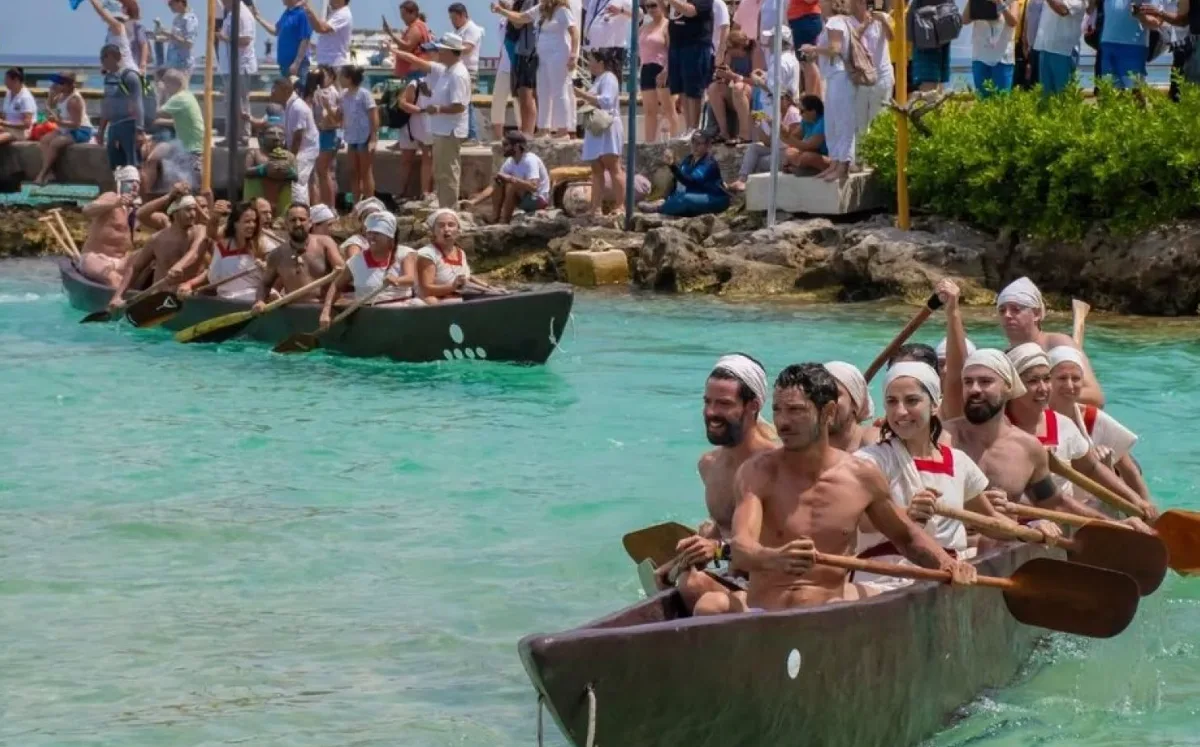 Canoeists paddling across open water between Playa del Carmen and Cozumel during Grupo Xcaret's ancestral crossing event