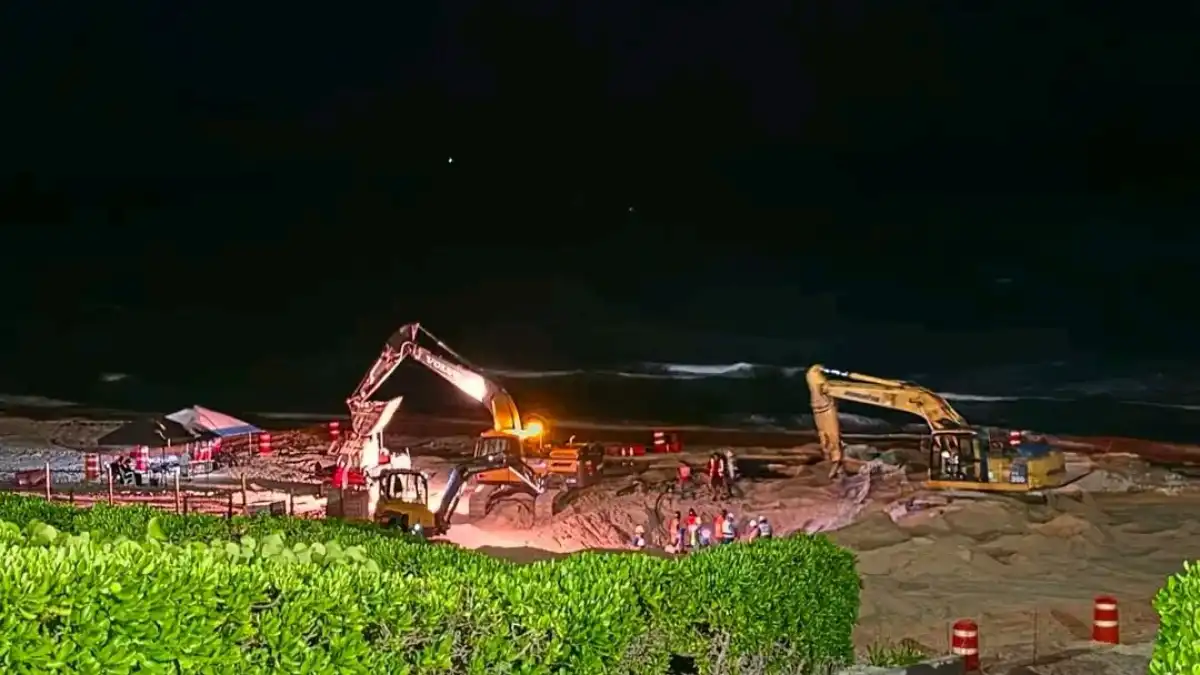 Heavy construction machinery parked on the sand at Playa Delfines in Cancún, a sea turtle nesting area, during nighttime work