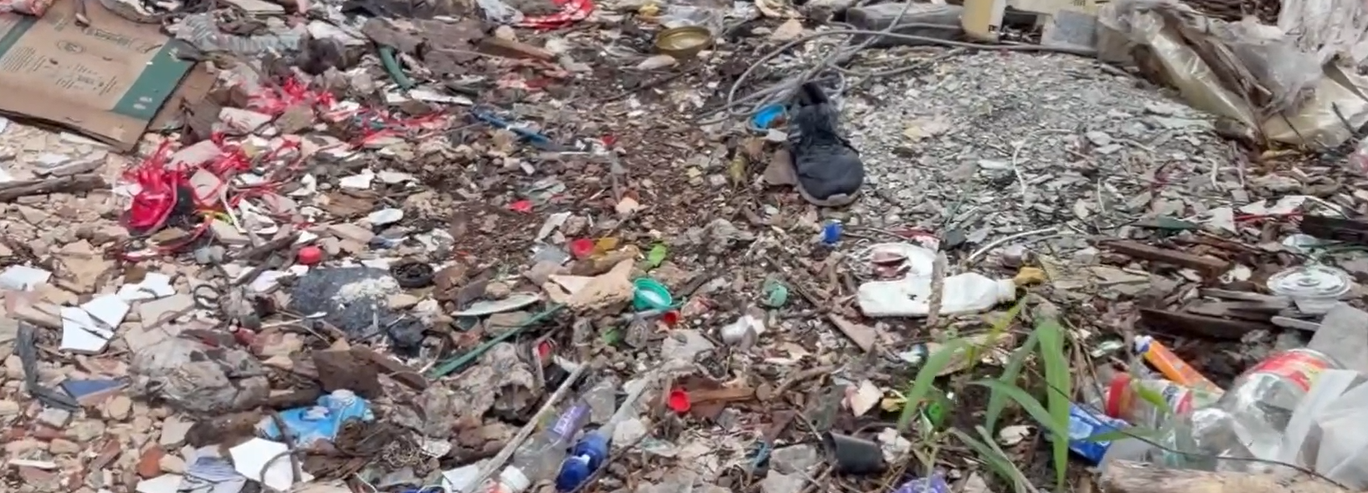 Vacant lot on Avenida 45 in Playa del Carmen's Gonzalo Guerrero neighborhood littered with trash, tires and construction debris