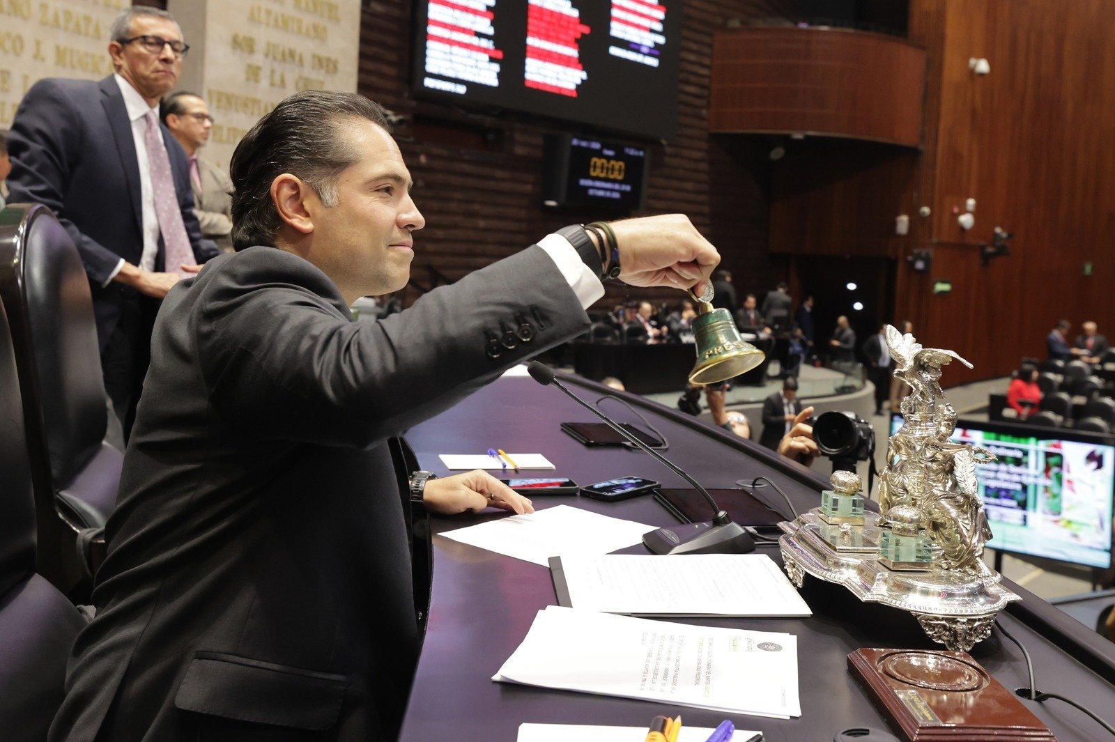 Mexican lawmakers raise hands and display banners during a floor vote in the Chamber of Deputies in Mexico City