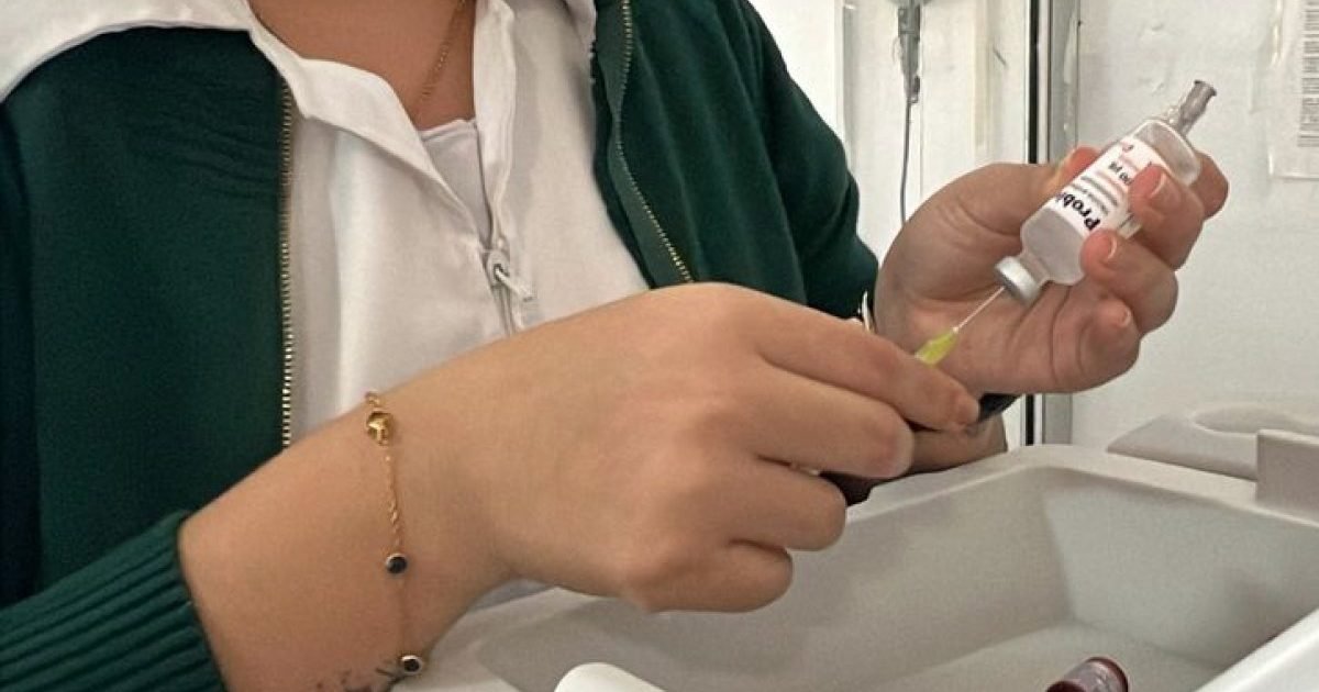 A health worker prepares a Moderna COVID-19 vaccine dose for a child during a winter vaccination campaign in Cancún, Quintana Roo