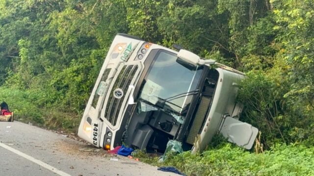 Wreckage of an overturned hotel staff bus beside Federal Highway 307 near the Tulum International Airport access road in Quintana Roo