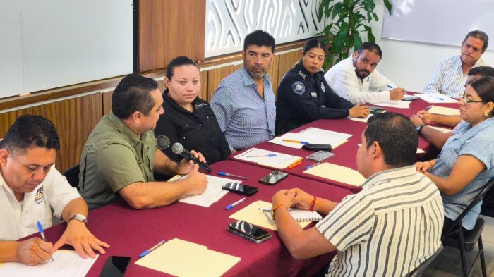 Officials and transport company representatives seated around a table during a working meeting in Playa del Carmen