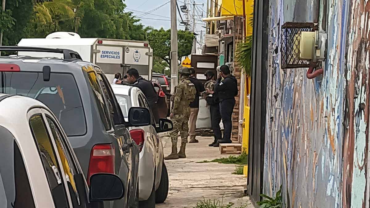Police officers and seized vehicles on a Cancún street following the investigation into a woman's killing in Supermanzana 38