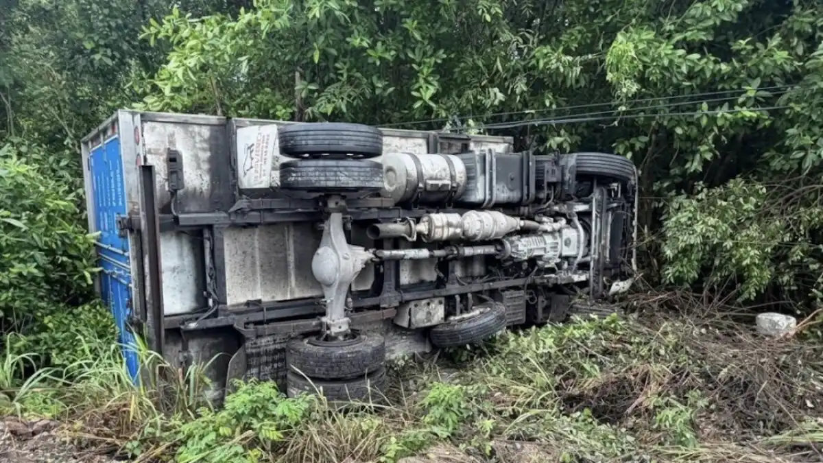 A red pickup truck lying upside down on the shoulder of Federal Highway 307 near Playa del Carmen after a rollover accident