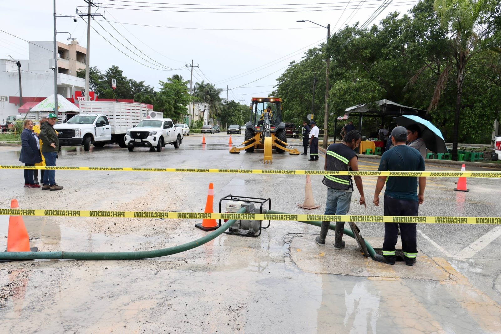 Cracked asphalt and standing water at the intersection of Avenida Joaquín Zetina Gasca and Calle Delfín in Puerto Morelos, where a ruptured water main prompted road closures