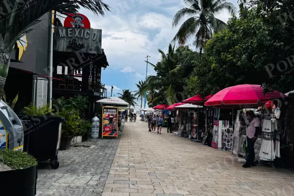 Empty sidewalk and shuttered storefronts along Quinta Avenida in Playa del Carmen, where tourism workers have been laid off
